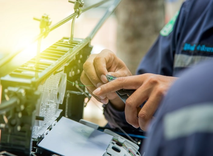 a fiber optic technician is performing fiber optic cabling and connect the optical fibers at the junctions which is important in fiber optics speeds
